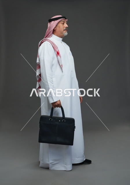 رجل اعمال عربي سعودي خليجي  يرتدي الزي الثوب الابيض والشماغ ويحمل حقيبة اللابتوب,  ايماءات واشارات مختلفه , كامل الجسم, خلفيه رماديه
