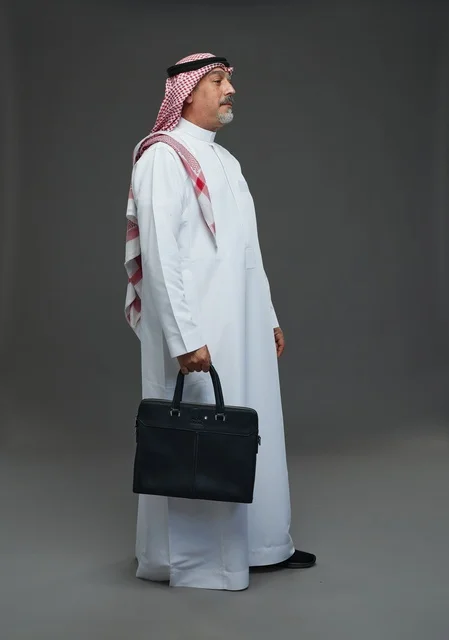 A Saudi Arabian Gulf businessman wearing a white thobe and a shemagh, carrying a laptop bag, with various gestures and signals, full body, gray background.