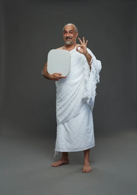 A portrait of a Saudi pilgrim in Ihram clothing holding a blank white square board while performing the rituals, with various gestures and signs, full body, gray background.