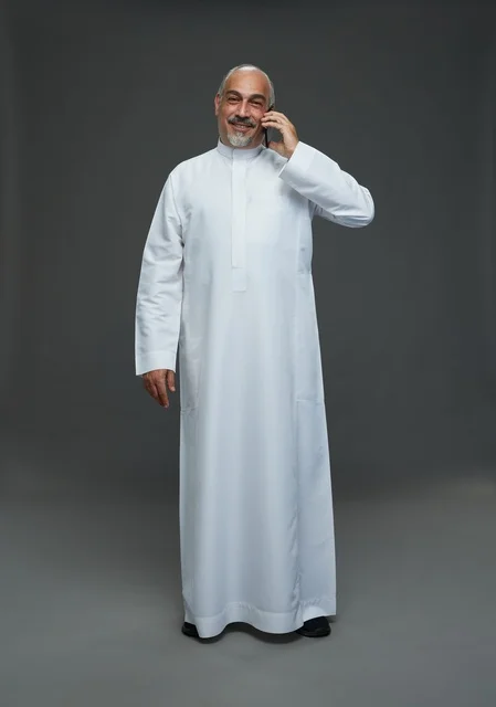 رجل  عربي سعودي خليجي مسن يرتدي الزي الثوب الابيض ويمسك الهاتف المحمول, اجراء مكالمه هاتفيه,  ايماءات واشارات مختلفه , كامل الجسم, خلفيه رماديه