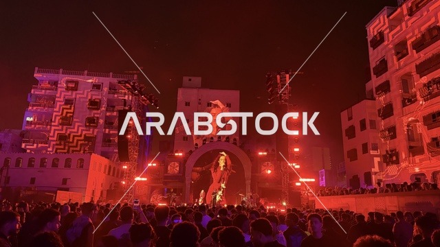 شخصية مضيئة في عرض موسيقي غنائي بفعالية بلد بيست في مدينة جدة التاريخية، المملكة العربية السعودية، مهرجان موسيقي وفني من تنظيم مدل بيست يوم 30 من يناير 2026،  تجربة فنية معاصرة، أجواء احتفالية نابضة بالطاقة، تفاعل جماهيري واسع، الموسيقى والفن في قلب جدة وعلى مقربة من ساحل البحر الأحمر.