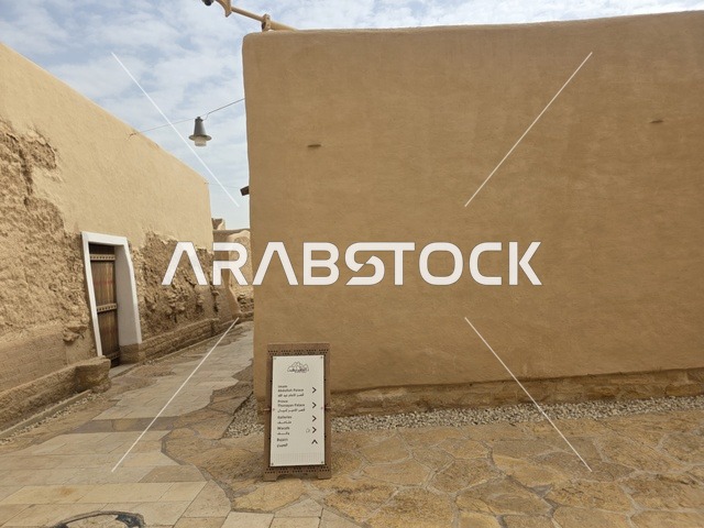 Clay structures built in the old style, green palm trees, the old walls of Diriyah in the city of Riyadh in the Kingdom of Saudi Arabia, ancient historical archaeological landmarks, ancient architectural engineering art, a picture of the archaeological buildings and clay houses in the Al-Turaif neighborhood in Diriyah.