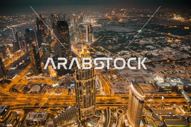 The architectural engineering art in the modern style of towers and skyscrapers, famous landmarks and tourist attractions in the city of Dubai, buildings and commercial establishments in the United Arab Emirates, attracting and drawing tourists from around the world, the growth and urban development of the illuminated financial towers of the Emirates at night.