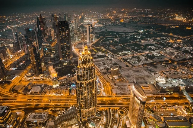 The architectural engineering art in the modern style of towers and skyscrapers, famous landmarks and tourist attractions in the city of Dubai, buildings and commercial establishments in the United Arab Emirates, attracting and drawing tourists from around the world, the growth and urban development of the illuminated financial towers of the Emirates at night.