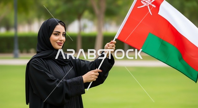 الاحتفال بالأعياد والمناسبات الوطنية, حب الوطن والانتماء إليه، إمرأة عربية خليجية عمانية ترتدي الحجاب والعباءة تمسك علم السلطنة، ذكرى اليوم الوطني العماني 18 نوفمبر، إحياء ذكرى تأسيس الدولة 1775 م، الاعتزاز والفخر بالرموز والراية