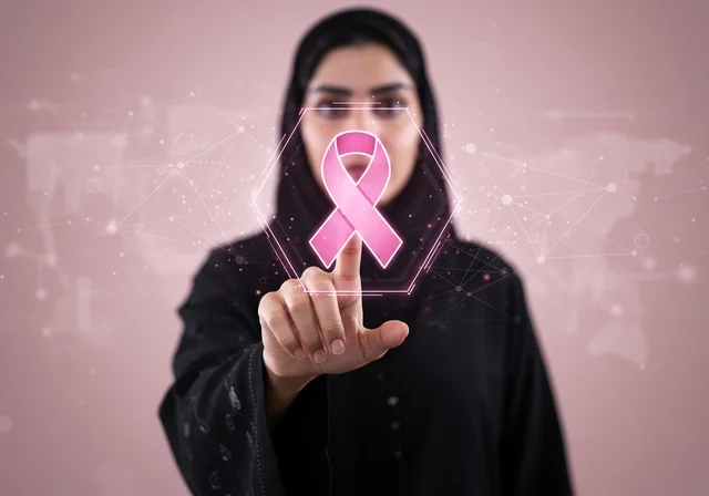 The slogan for breast cancer awareness using hologram technology, an Arab Gulf Saudi woman wearing an abaya and hijab, focusing on the disease and early detection, challenging malignant diseases, the symbol of the global women's campaign, the International Day for Breast Cancer Awareness.