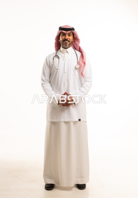 Hand expressions, hands intertwined, looking at the camera with gestures of self-confidence, attention to appearance, providing medical examinations and treatment services, a close-up portrait of a smiling Arab Gulf Saudi doctor wearing a doctor's coat and stethoscope, the concept of healthcare, white background.