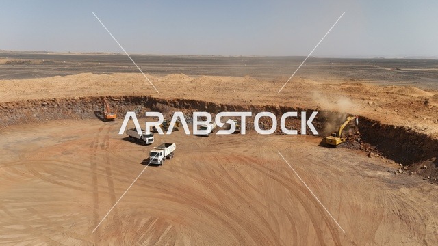 مفهوم الهندسة المعمارية والإنشاءات، جرافات ضخمة تعمل في الحفر ورفع الأنقاض والأتربة في موقع العمل، الاعتماد على الآلات والمعدات الثقيلة في أعمال البناء، مهنة ووظيفة هندسية صناعية في السعودية، تحسين البنية التحتية لإقامة المباني والمشاريع الحديثة في مدينة الرياض