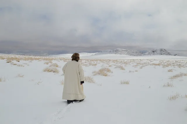 رجل يرتدي الفرو لتدفئة من الثلوج في نيوم، صورة من قمة جبل اللوز بمنطقة تبوك ، التضاريس و المناخ في السعوديه, جبال اللوز المثلجة في منطقة تبوك في المملكة العربية السعودية,  مناظر و أماكن طبيعية سياحية، المناطق الجبلية في السعودية ، وجهة العالم الجديدة في قلب نيوم