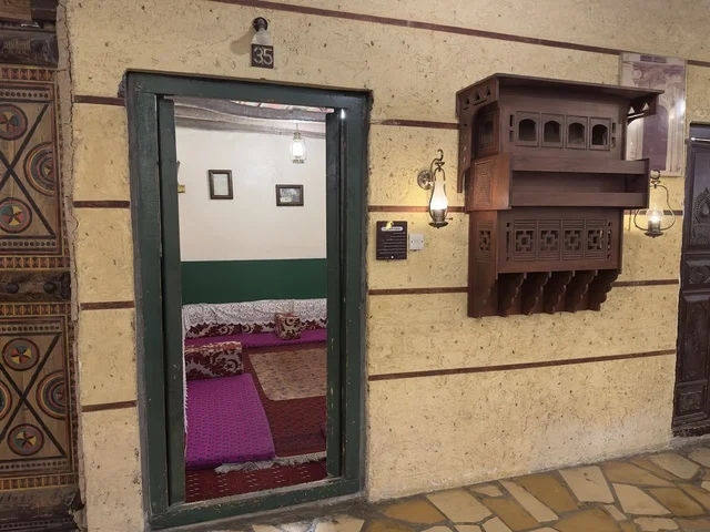 Hotel room number 35, a sign for the Hijaz corner hanging from a thatched and wooden ceiling, a rural or historical environment, the heritage village is a prominent museum and restaurant located on the Corniche of Dammam in the Kingdom of Saudi Arabia.