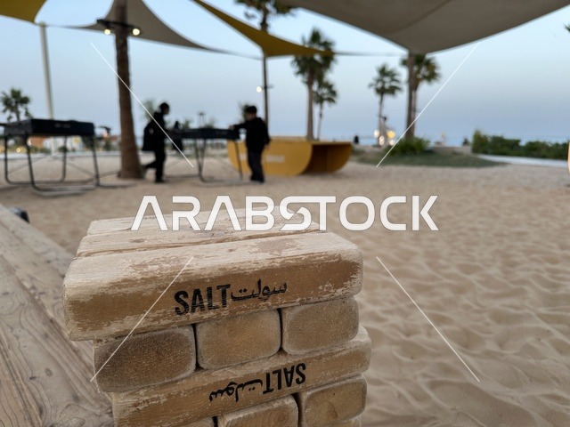 كتلة الخشبية في المقدمة تحمل اسم سولت،  شاطئ رملي مع وجود مظلات وأشجار نخيل، سولت البحر وجهة ترفيهية وشاطئية عائلية تقع على طريق الكورنيش في الخبر في المملكة العربية السعودية، تجديدات إضافية وتطويرات في 3  يناير 2026