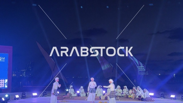 A theatrical performance where the performers wear traditional clothing at the Wooden Ships Festival on the Al-Hamra Beach in Jeddah, Saudi Arabia, from January 12 to 16, 2026. The performances showcase the stages of traditional shipbuilding, the tools and materials used, maritime heritage and coastal identity, interactive activities, and cultural shows.