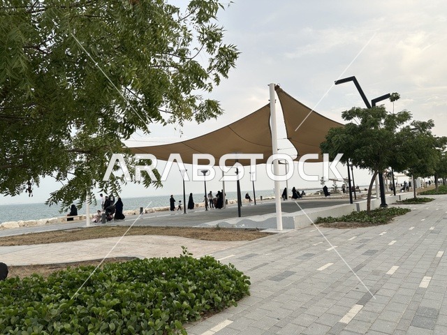 A modern walking experience, Hams Walk in the Eastern Province, Saudi Arabia, a calm family atmosphere, an open recreational destination, spaces for walking and relaxation, outdoor seating and benches.