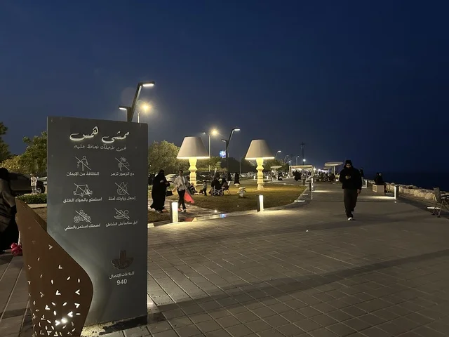 Hams Walk in the Eastern Province at night, Saudi Arabia, a calm family atmosphere, a modern walking experience, an open entertainment destination, spaces for walking and relaxation, outdoor seating and benches.