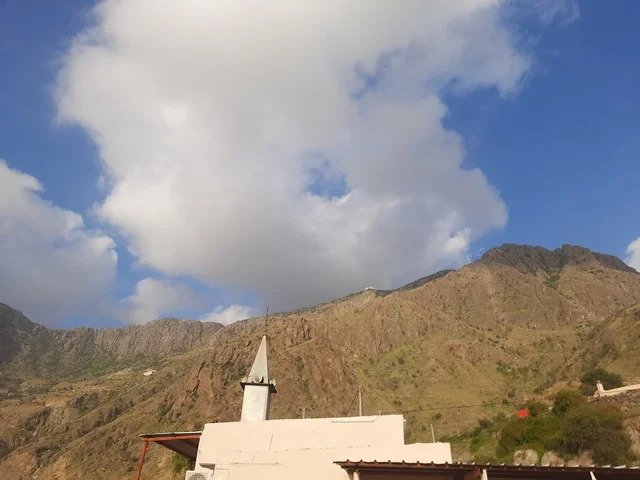 Sacred religious landmarks in mountainous areas, parks and recreational gardens in the Kingdom, architectural engineering art for building mosques in Saudi Arabia, terrain in mountain peaks and highlands, tourist attractions in the Al-Hijrah area in the city of Al-Baha, enjoying the calm atmosphere at sunset.