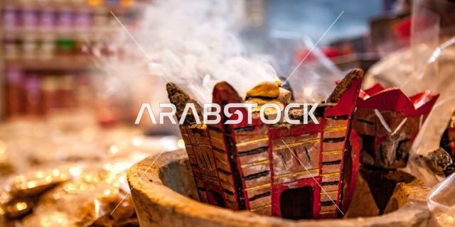 منتج وطني محلي سعودي، خشب العود الفاخر والفحم، منظر الدخان المنتشر من البخور، أصالة العادات والتقاليد في المملكة العربية السعودية، التعطر والتطيب باطيب الروائح والعطور، مبخرة معدنية في مكان تراثي