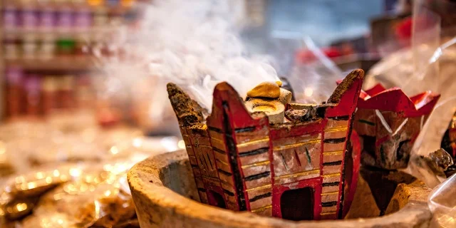 A local Saudi national product, luxurious oud wood and charcoal, the sight of smoke spreading from the incense, the authenticity of customs and traditions in the Kingdom of Saudi Arabia, perfuming and scenting with the finest fragrances and perfumes, a metal incense burner in a heritage place.