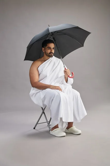 Saudi Man in Ihram Holding Umbrella in Studio