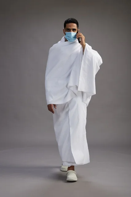 Arab Man in Ihram with Smartphone and Face Mask