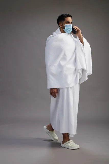 Saudi Man in Ihram Using Smartphone with Medical Mask