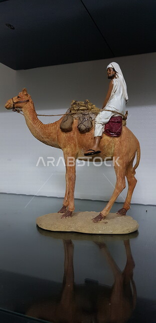 مجسم لجمل يركب على ظهره رجل، السفر و الترحال ،  التجارة والتنقل ، وسيلة مواصلات قديمة ، تراث وشعبيات