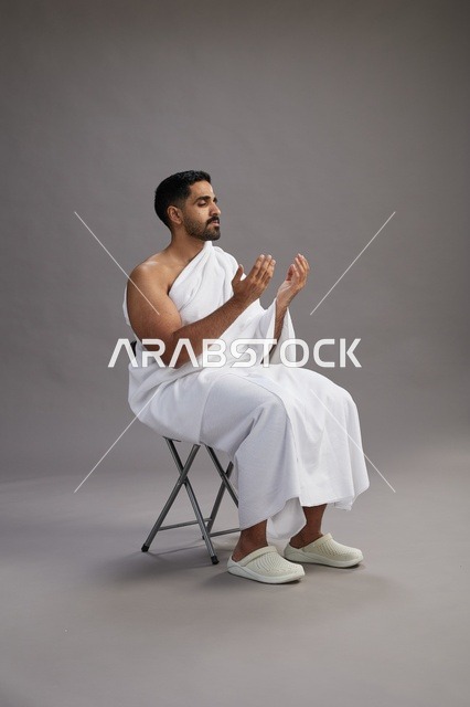 حاج سعودي بملابس الإحرام يدعو في الاستوديو
