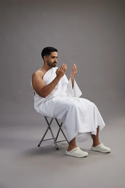 حاج سعودي بملابس الإحرام يدعو في الاستوديو