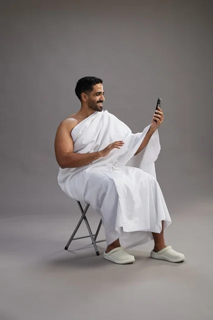حاج سعودي بملابس الإحرام يجري مكالمة فيديو بالاستوديو
