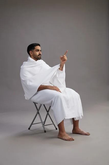 Saudi Pilgrim in Ihram Sitting and Pointing Upward