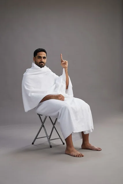 Saudi Pilgrim in Ihram Pointing Up in Studio