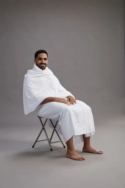 حاج سعودي بملابس الإحرام جالس على كرسي بالاستوديو