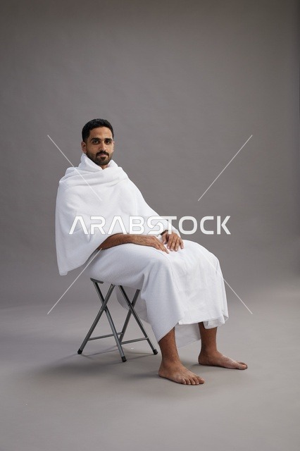 حاج سعودي بملابس الإحرام جالس حافي القدمين