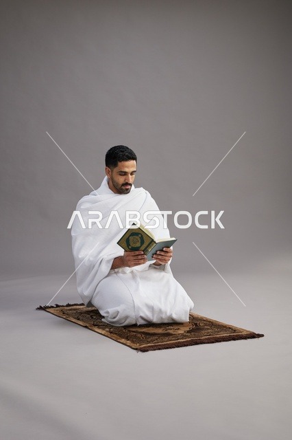 حاج سعودي بملابس الإحرام يقرأ القرآن الكريم