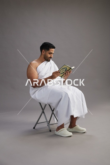 حاج سعودي بملابس الإحرام يقرأ القرآن في الاستوديو