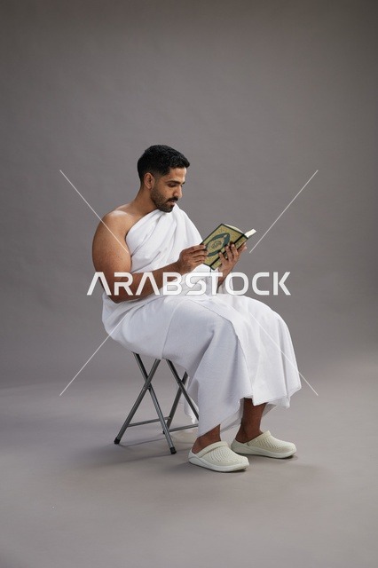 حاج سعودي بملابس الإحرام يقرأ القرآن في استوديو