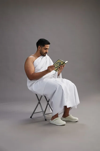 حاج سعودي بملابس الإحرام يقرأ القرآن في استوديو