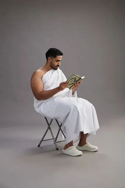 حاج سعودي بملابس الإحرام يقرأ القرآن في الاستوديو