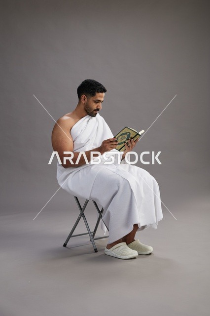 حاج سعودي بملابس الإحرام يقرأ القرآن في الاستوديو