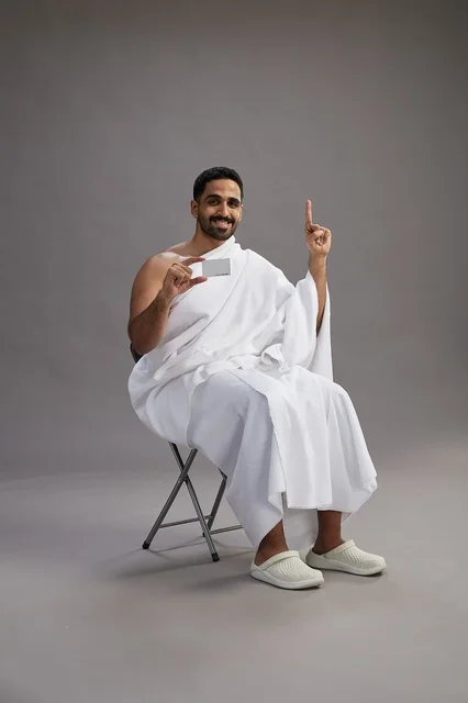 حاج سعودي بملابس الإحرام يجري عملية دفع إلكتروني