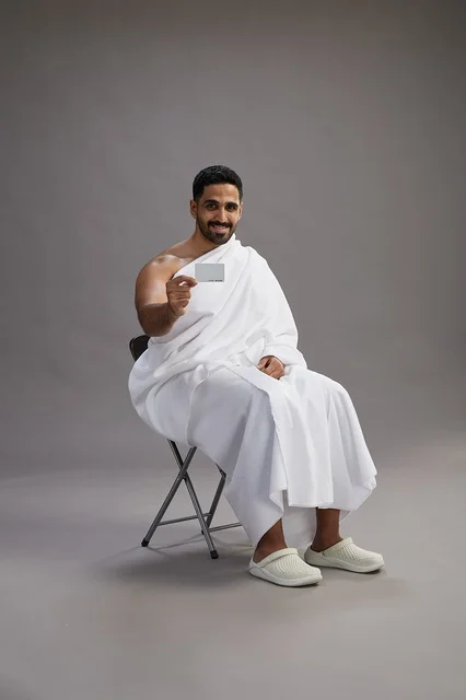حاج سعودي بملابس الإحرام يحمل بطاقة دفع