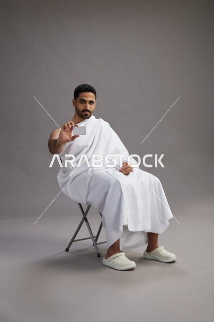 Saudi Pilgrim in Ihram Holding Bank Card Studio Shot