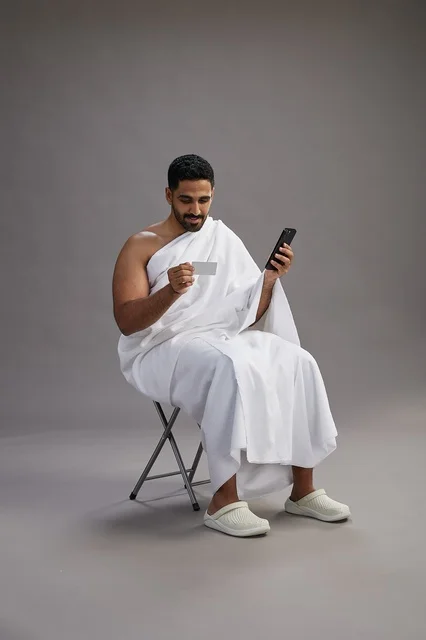 حاج سعودي بملابس الإحرام يجري عملية دفع إلكتروني