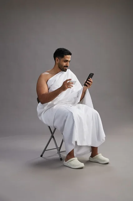 حاج سعودي بملابس الإحرام يجري عملية دفع إلكتروني