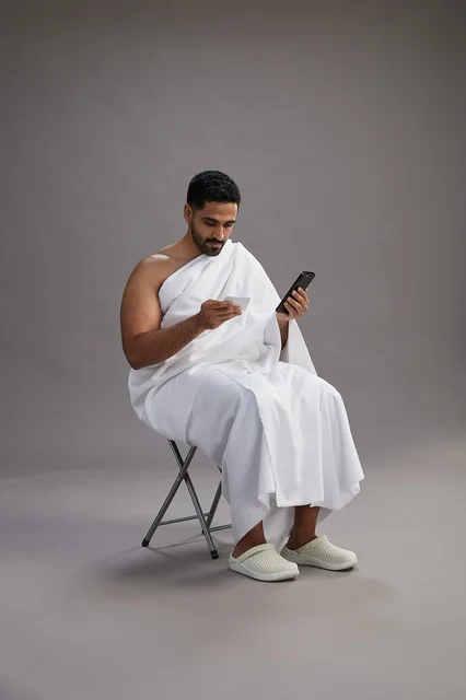 حاج سعودي بملابس الإحرام يجري عملية دفع إلكتروني