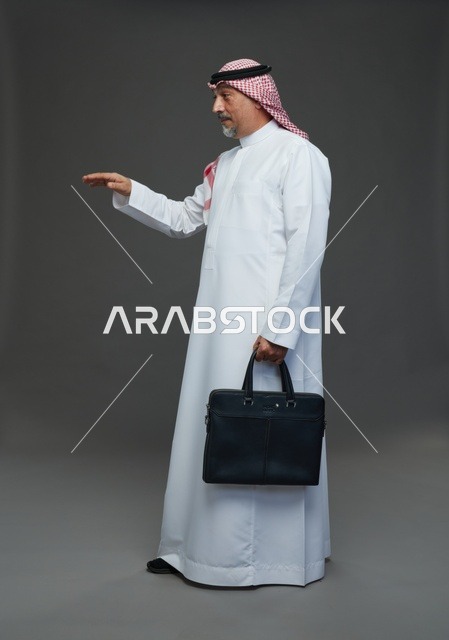 رجل اعمال عربي سعودي خليجي  يرتدي الزي الثوب الابيض والشماغ ويحمل حقيبة اللابتوب,  ايماءات واشارات مختلفه , كامل الجسم, خلفيه رماديه