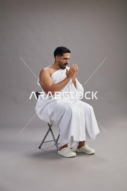رجل سعودي بملابس الإحرام يعطس في استوديو