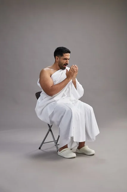 Saudi Pilgrim in Ihram Sneezing on Grey Background