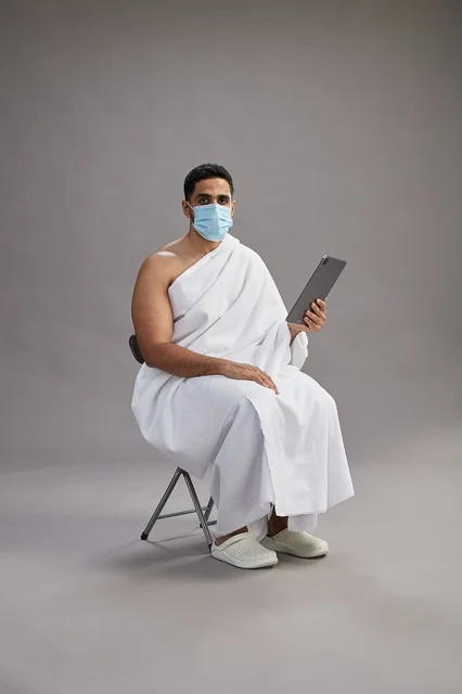 Saudi Man in Ihram with Mask and Tablet in Studio