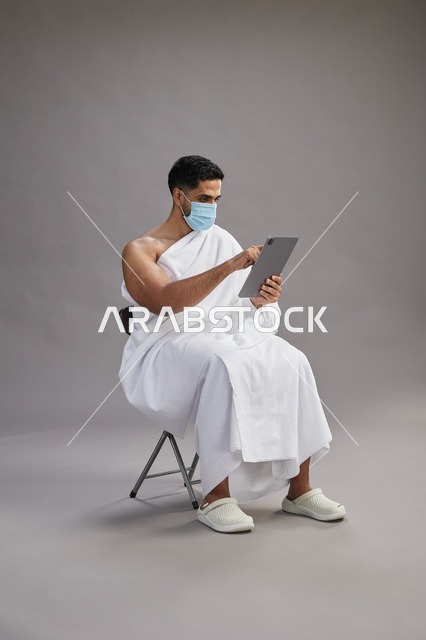 Saudi Man in Ihram Using Digital Tablet Wearing Face Mask