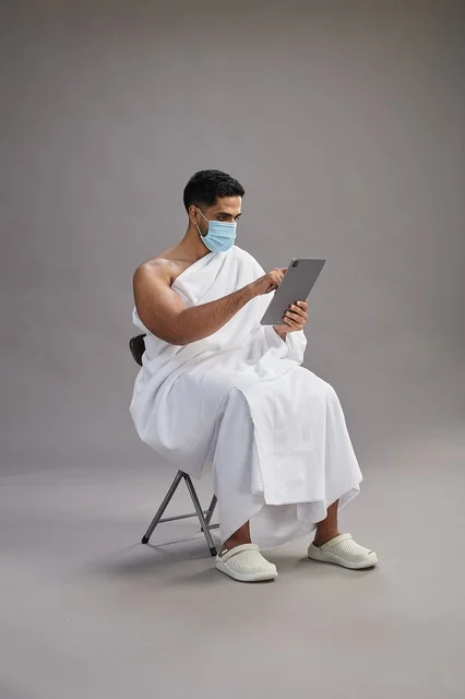 Saudi Man in Ihram Using Digital Tablet Wearing Face Mask